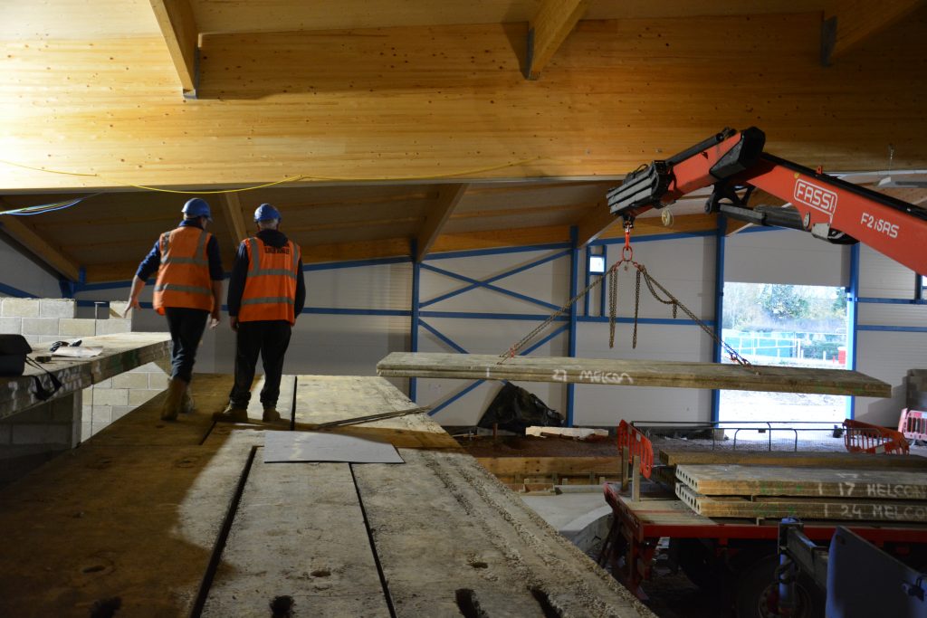 indoor crane lifting hollowcore planks into position