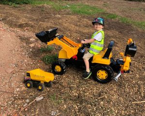 Young boy riding plastic digger