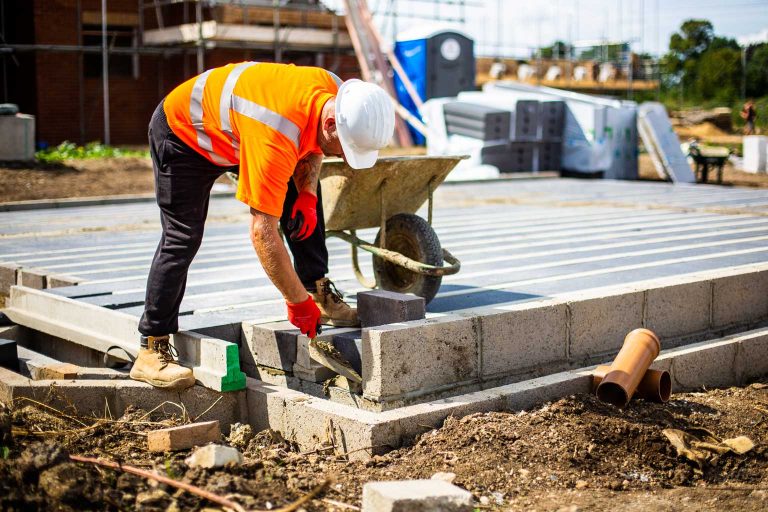worker cementing block at the end of site
