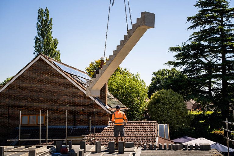 installer waiting for crane to lower precast concrete stairs